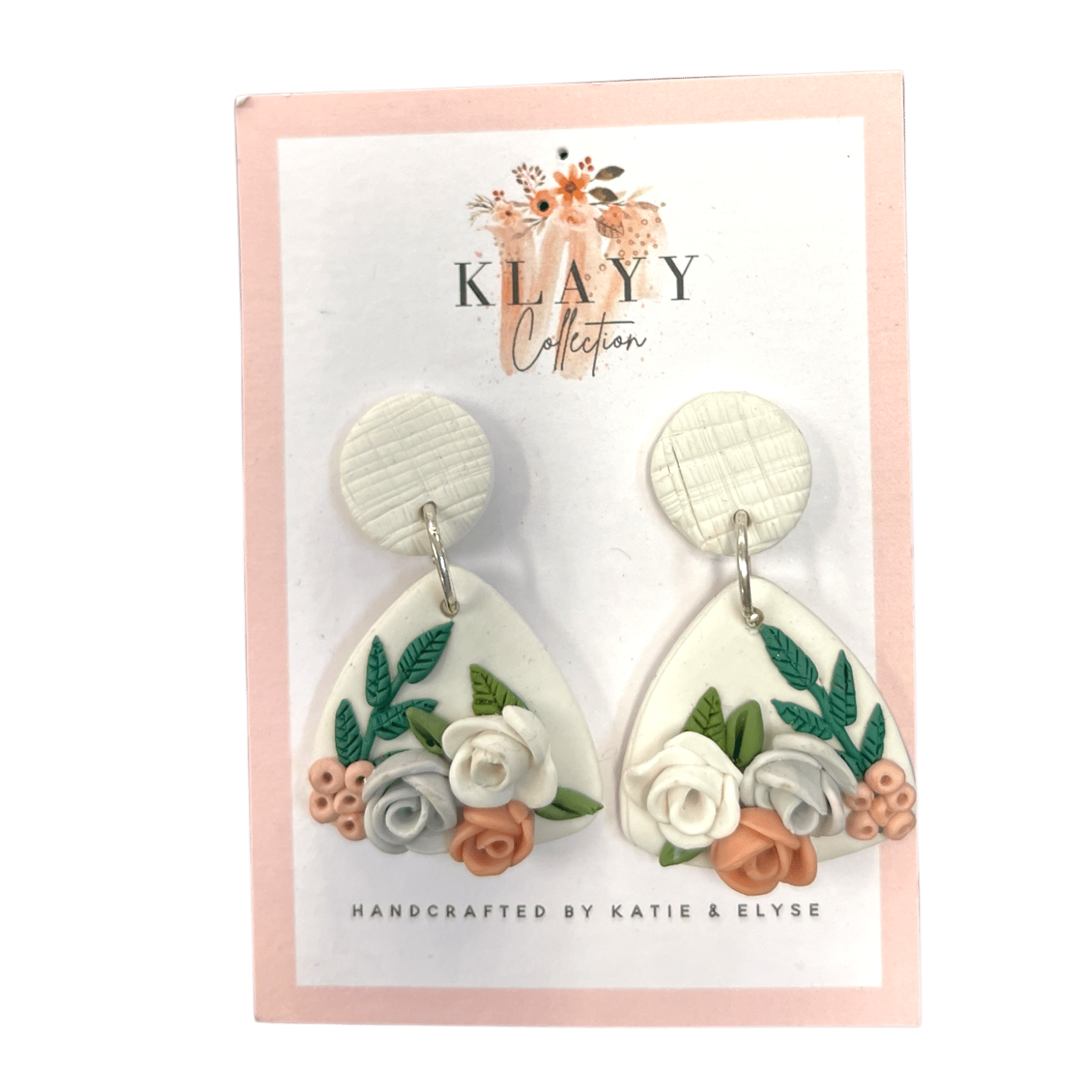 Blush Botanica earrings feature sculpted pastel roses and leaves on white teardrops with textured white studs. Soft, romantic, and handmade.