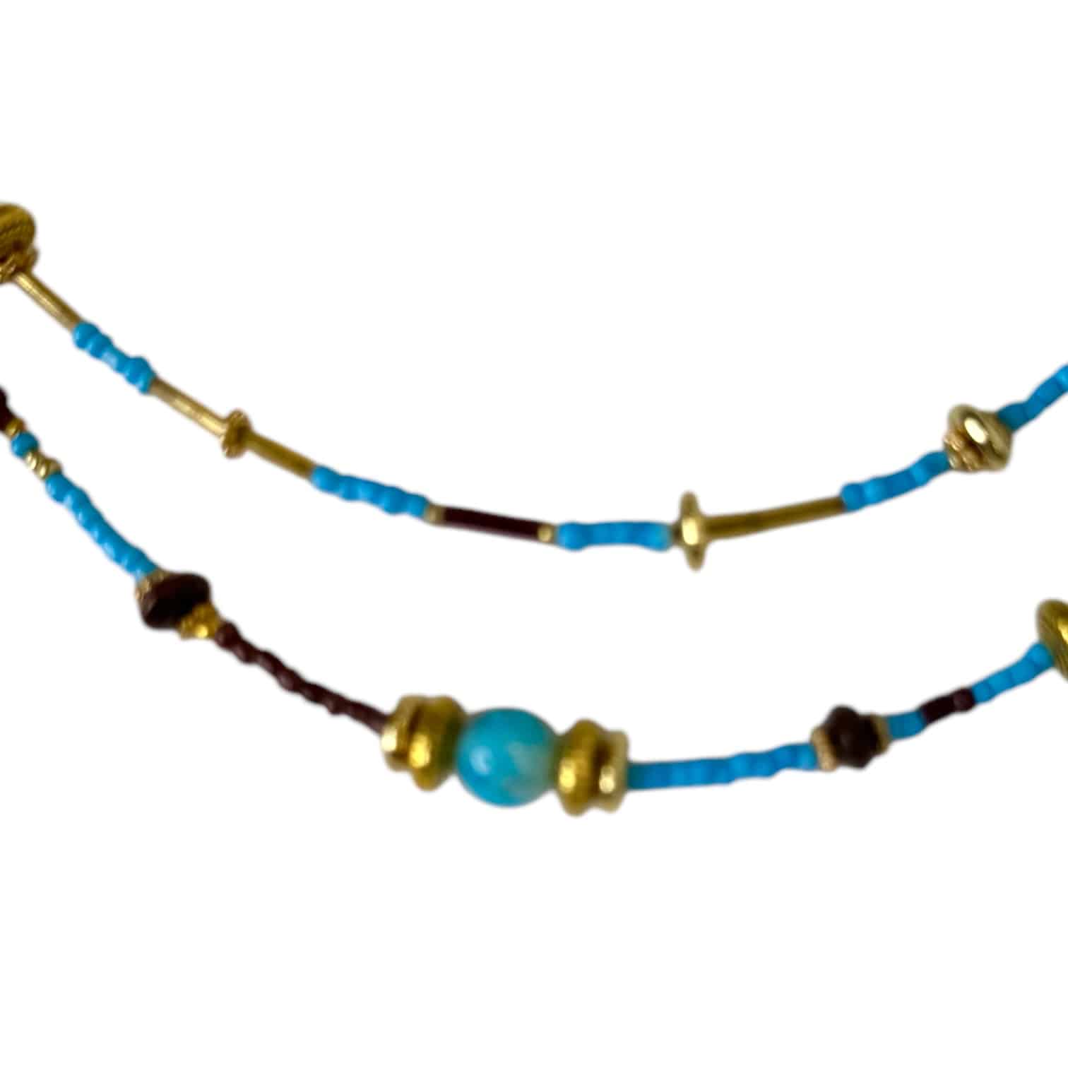 The Desert Sky Necklace by Art In Stone Jewellery features turquoise, brown beads, and gold accents, inspired by earthy landscapes and open skies.