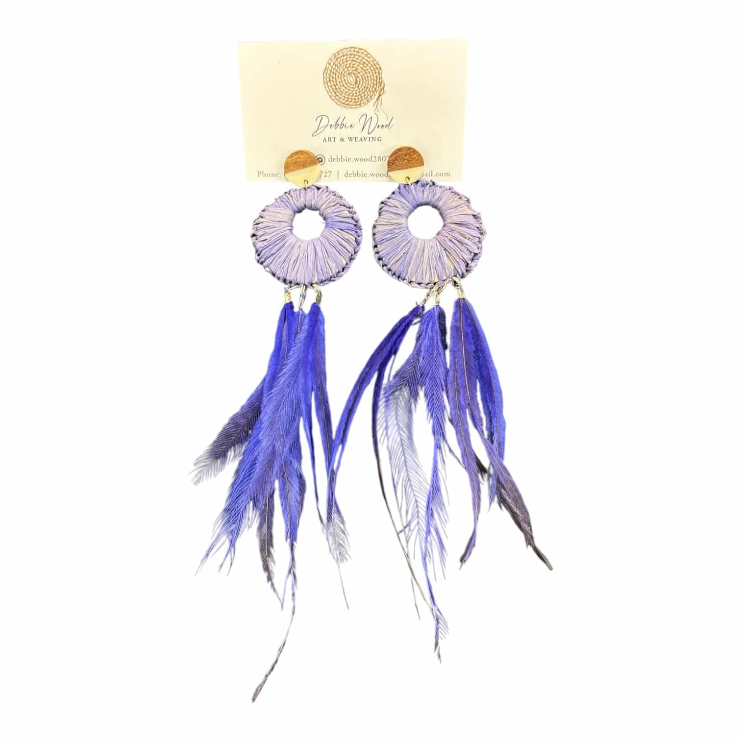 Soar in style with the Sky Spirit Earrings by Debbie Wood. Handwoven purple raffia and vibrant blue emu feathers bring bold, colourful energy to any look.