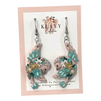 Daisy Dancers by Klayy Collection – handmade polymer clay swallow earrings with floral details. Lightweight, whimsical & full of joyful movement.