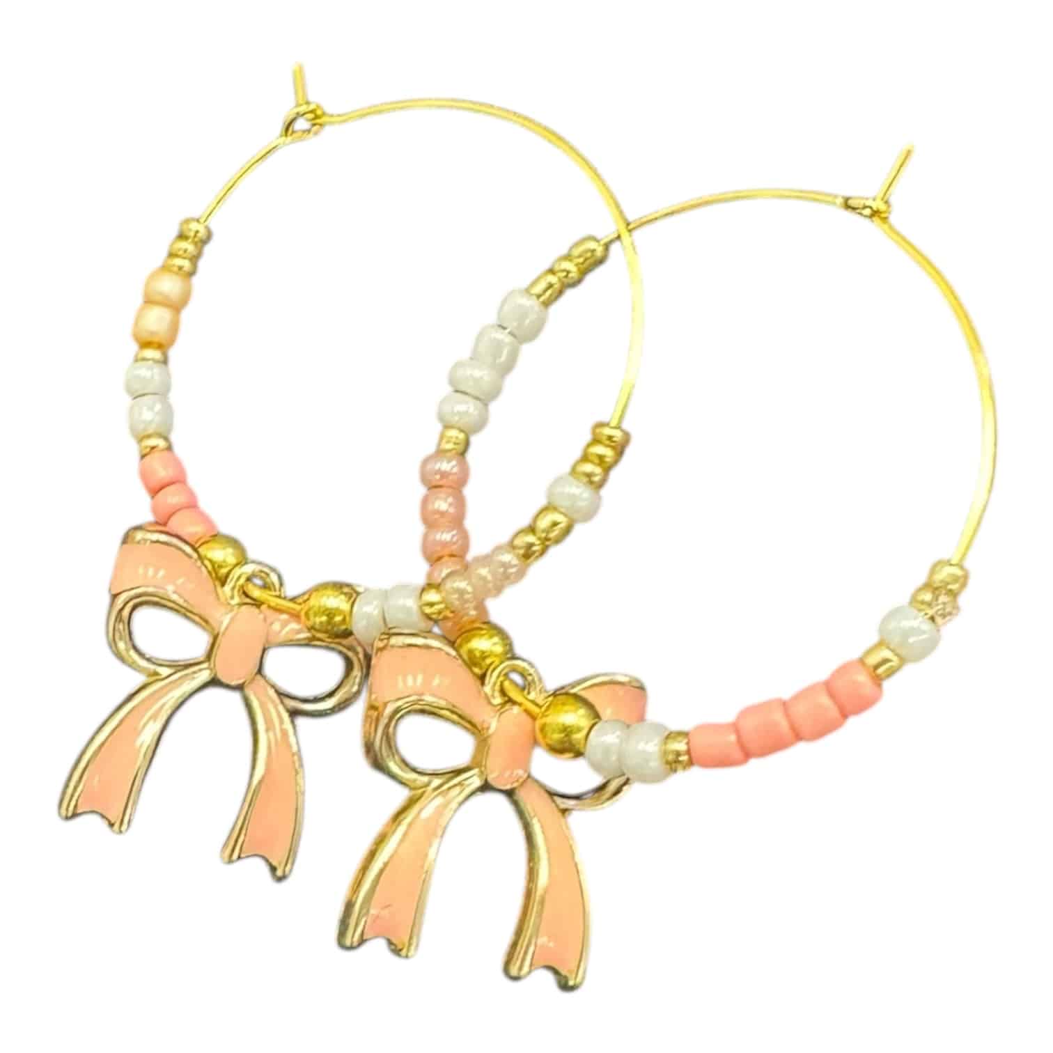 Peachy Bow Hoops by Art in Stone — handmade blush pink enamel bow hoop earrings with pastel beads for elegant, playful charm.