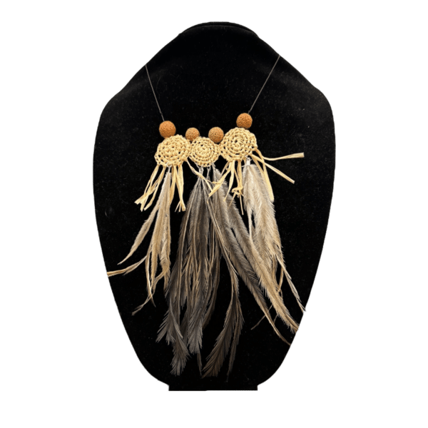 Celebrate cultural heritage with the "Emu Spirit Necklace" by Gomeroi artist Debbie Wood, part of "The NAIDOC Collection." This handwoven necklace features raffia, emu feathers, and quandong seeds, showcasing traditional craftsmanship and natural elegance.