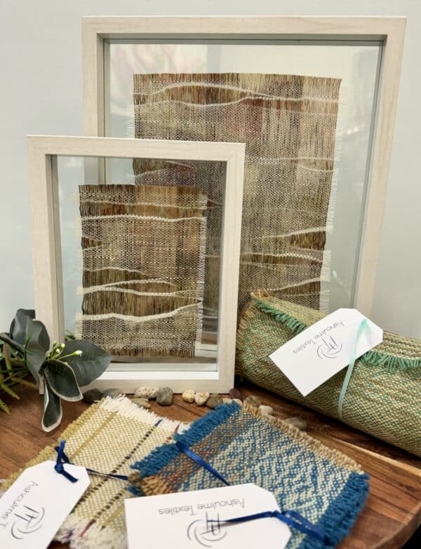 Explore "Whispering Meadows" by Ashculme Textiles, an intricate artwork made from hand-reared alpaca wool and silk, dyed with natural bush leaves. This piece captures the serene beauty of the Australian outback, framed between glass panels for a detailed and captivating display.