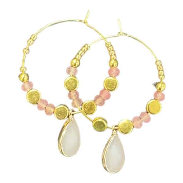 Shine with the Golden Sands earrings by Maggie Deall, featuring golden and blush pink beads with a delicate teardrop charm. Perfect for any occasion.