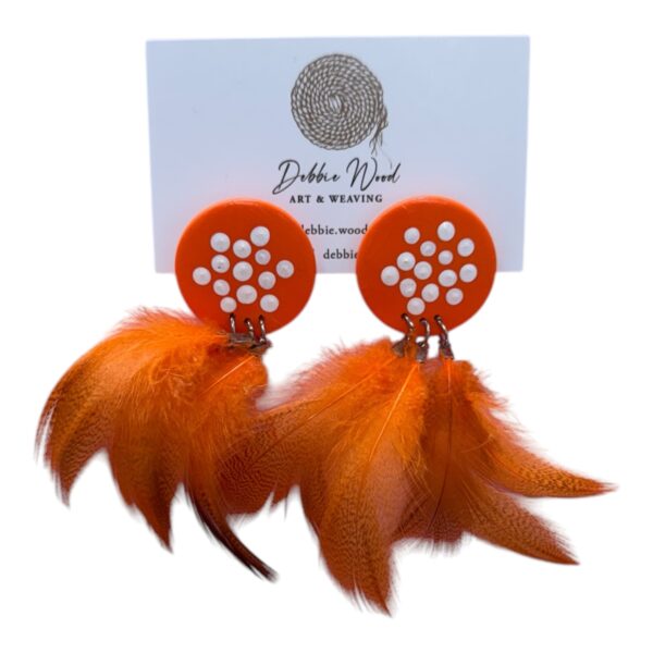Ember Glow Earrings by Gomeroi artist Debbie Wood – hand-painted orange wooden studs with white dots and ethically sourced feathers.