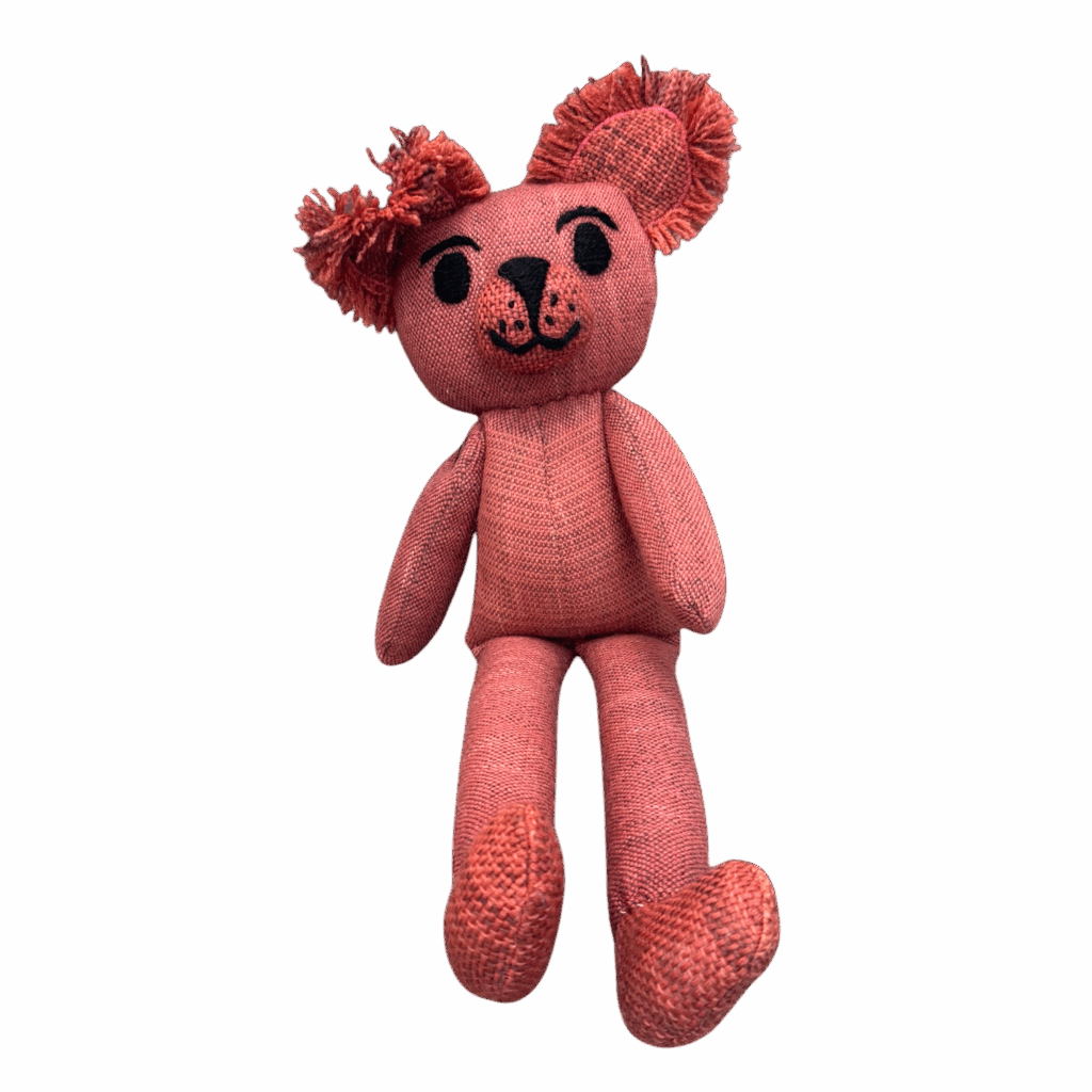 Rosie Roo is a handwoven teddy bear made from alpaca and merino wool, dyed in coral pink and full of charm.