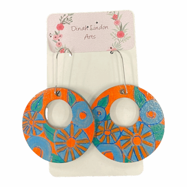 Retro Bloom Hoops by Dinah Lindon – handpainted round earrings with bold blue and orange floral designs on lightweight wood.