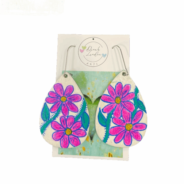 Cosmic Daisy Drops – bright teardrop earrings with pink daisies and green stems on a glossy white background by Dinah Lindon.