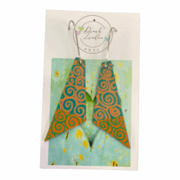 Desert Spiral Arrows – orange and teal arrowhead earrings with handpainted spiral patterns and a glossy finish by Dinah Lindon.