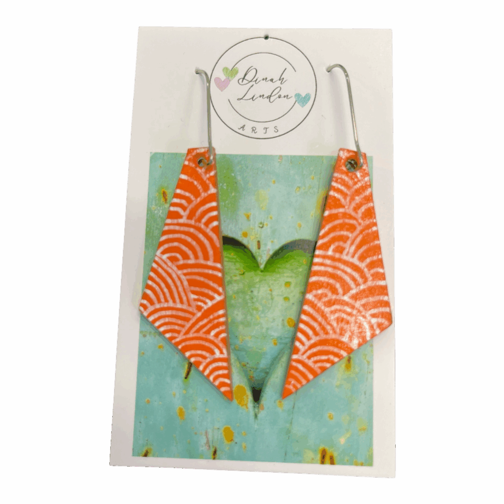 Coral Wave Arrows – bright coral earrings with white wave patterns in a sharp, angled shape.