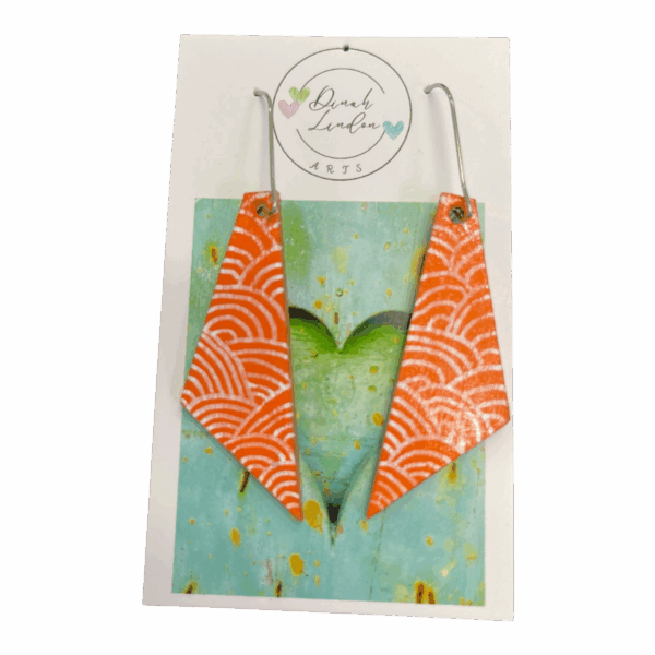 Coral Wave Arrows – bright coral earrings with white wave patterns in a sharp, angled shape.