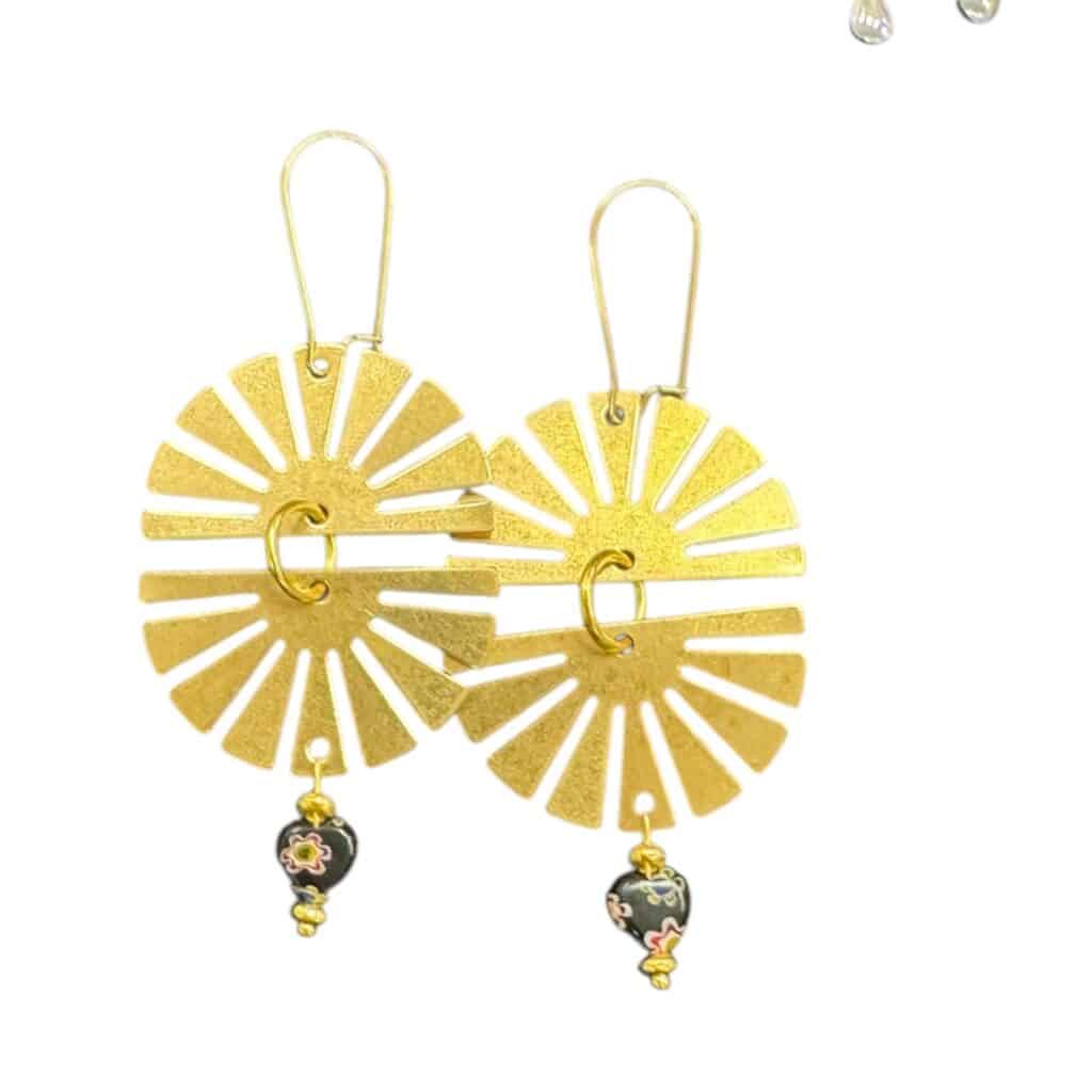 Golden and joyful, the Here Comes the Sun Earrings by Art in Stone radiate warmth and retro charm with their gold sunbursts and floral dangles.