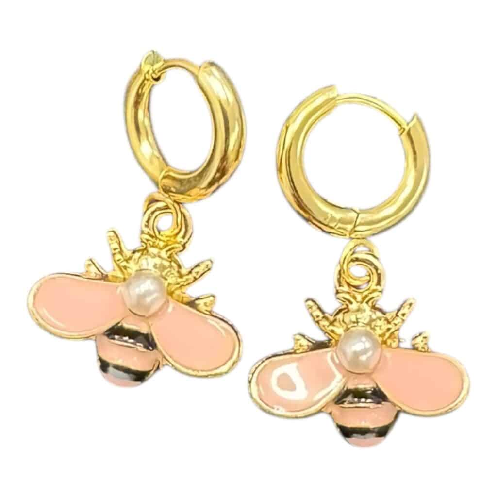 Buzz into style with Bee Happy Huggies — gold hoops featuring pink enamel bees with pearl detail for instant cheer.